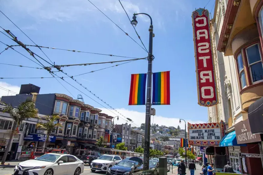 贝博体彩app的卡斯特罗社区, with the 卡斯特罗 Theater sign and rainbow flags in the foreground.