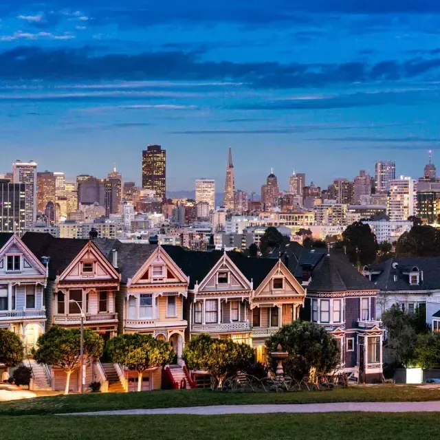 Las famosas Damas Pintadas de Alamo Square aparecen ante el horizonte de San Francisco al atardecer.